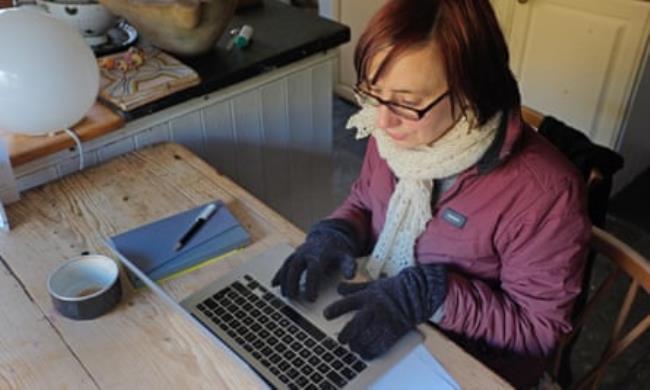 A woman works at home from her cold kitchen
