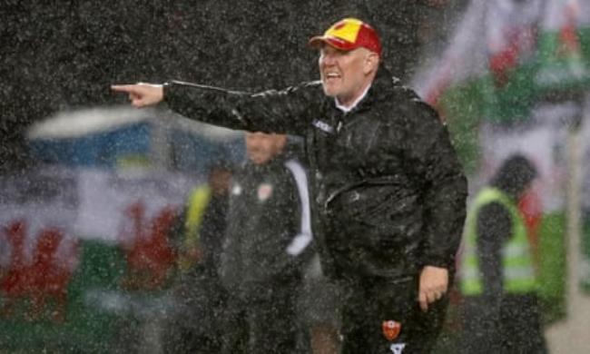 Robert Prosinecki, Montenegro’s head coach, gives instructions in the pouring rain.